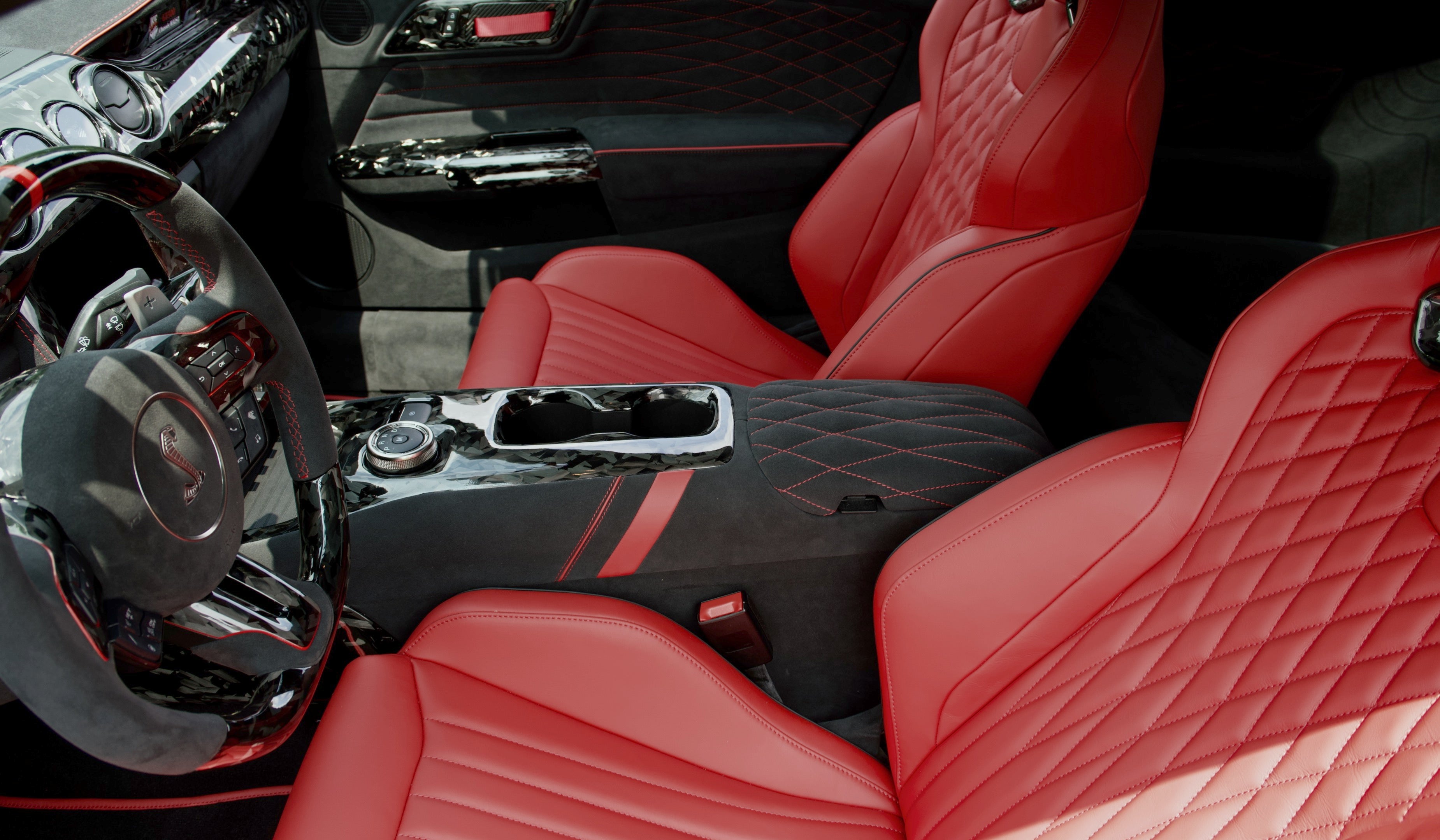 Mustang Red interior with premium leather seats, custom stitched armrest, and forged carbon fiber center console trim installed