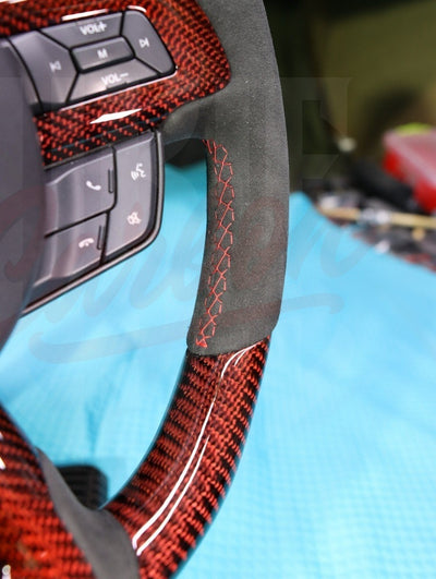 Detail of steering wheel stitching and stripe accent options on Alcantara and carbon fiber.